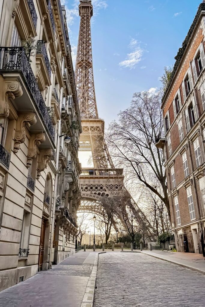 Quaint street scene in Paris showcasing the iconic Eiffel Tower amidst historic buildings.